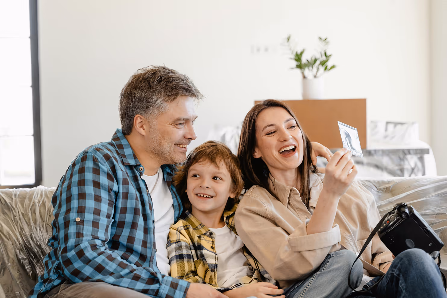 Young family sitting on the couch laughing